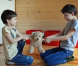 Two young siblings fighting for a teddy bear