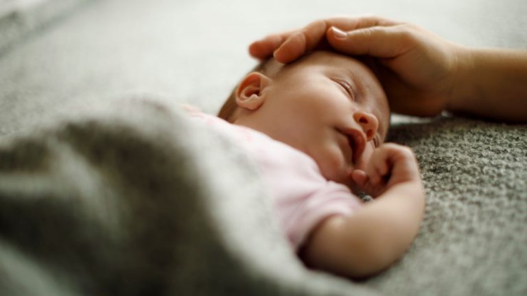 Mom caressing baby's head to calm Infant Shudder Syndrome